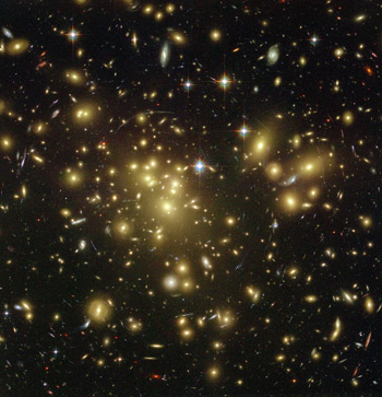 This image shows the galactic cluster Abell 1689, whose gravity distorts images of galaxies behind it (in the line of sight) through gravitational lensing. The mass obtained from lensing is far larger than the mass obtained from the luminous matter that is observed. 