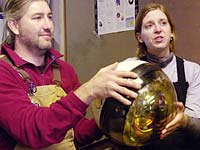 AMANDA researchers Darryn Schneider and Katherine Rawlins hold one of the light-detection modules