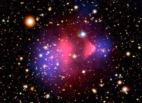 This image of the Bullet cluster shows a separation of dark matter from the luminous matter, with the dark matter shown in blue and the luminous matter shown in red. Image credit: X-ray: NASA/CXC/CfA/M.Markevitch et al.; Optical: NASA/STScI; Magellan/U.Arizona/D.Clowe et al.; Lensing Map: NASA/STScI; ESO WFI; Magellan/U.Arizona/D.Clowe et al.