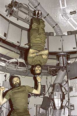 In the SkyLab orbiter, one astronaut balances another on his index finger. (photo courtesy of NASA)