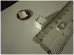 1/400th a sheet of paper on a penny, next to a cubic centimeter. 