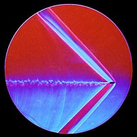 Schlieren image of the shock wave and turbulent wake of a bullet.