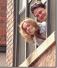 Anne and her husband, Sergio, leaning out the window of their home in Chicago.