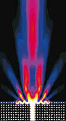 Corrugations in the surface of a simulated photonic crystal (bottom) coerce the upward-traveling light into a narrow beam as it leaves the crystal. This design may solve the problem of hooking up photonic crystals with conventional fiber optics. Image Credit: Phys. Rev. B 69, 121402 (2004)