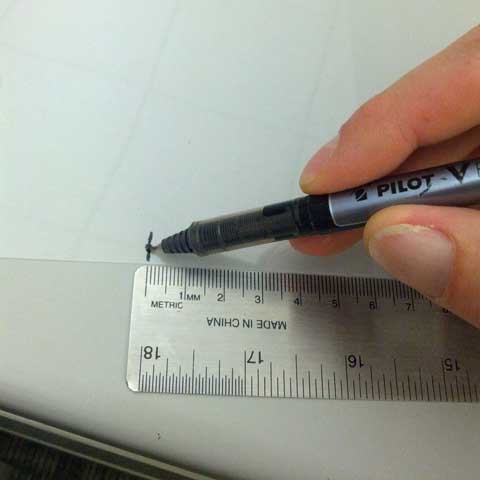 A pen is used to mark the transparency sheet